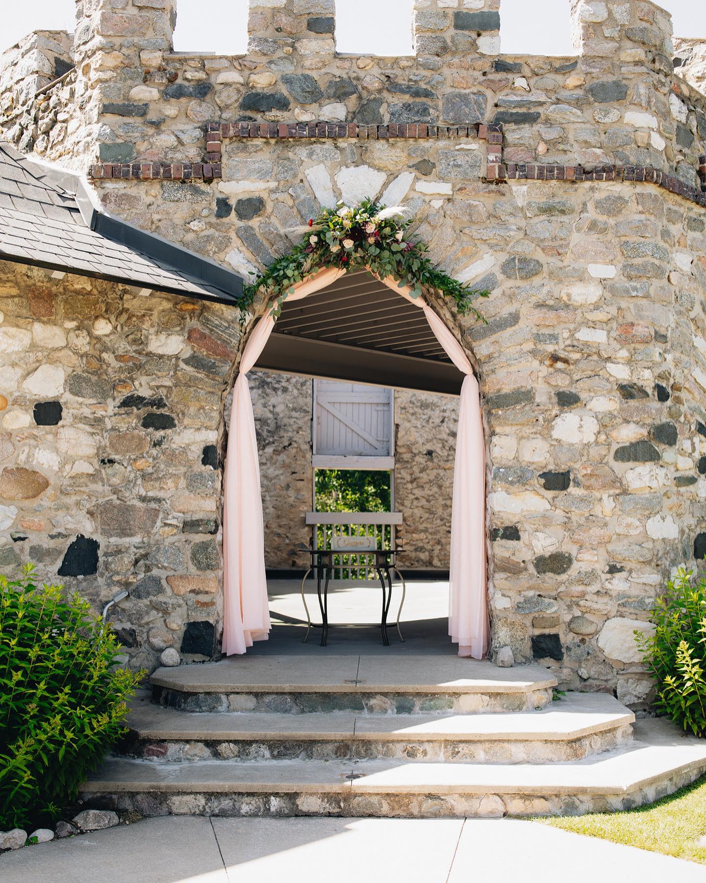 stone wedding ceremony arch with flowers