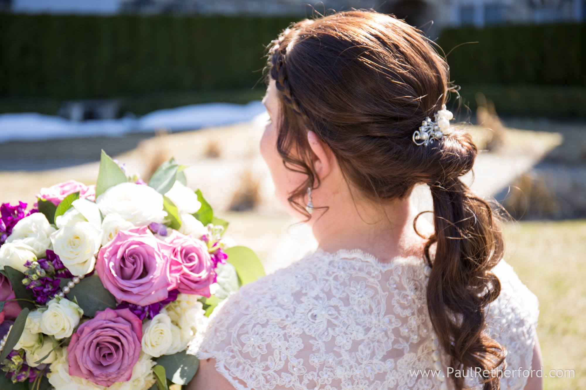 bride holding purple and white rose bridal bouquet