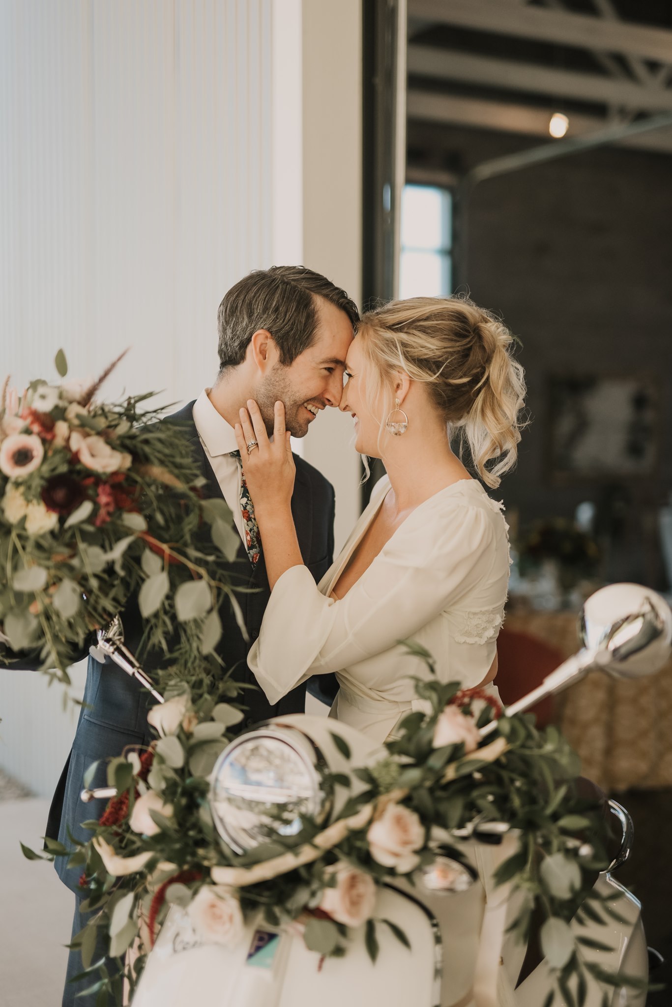 bride and groom on vespa covered in greenery and flowers